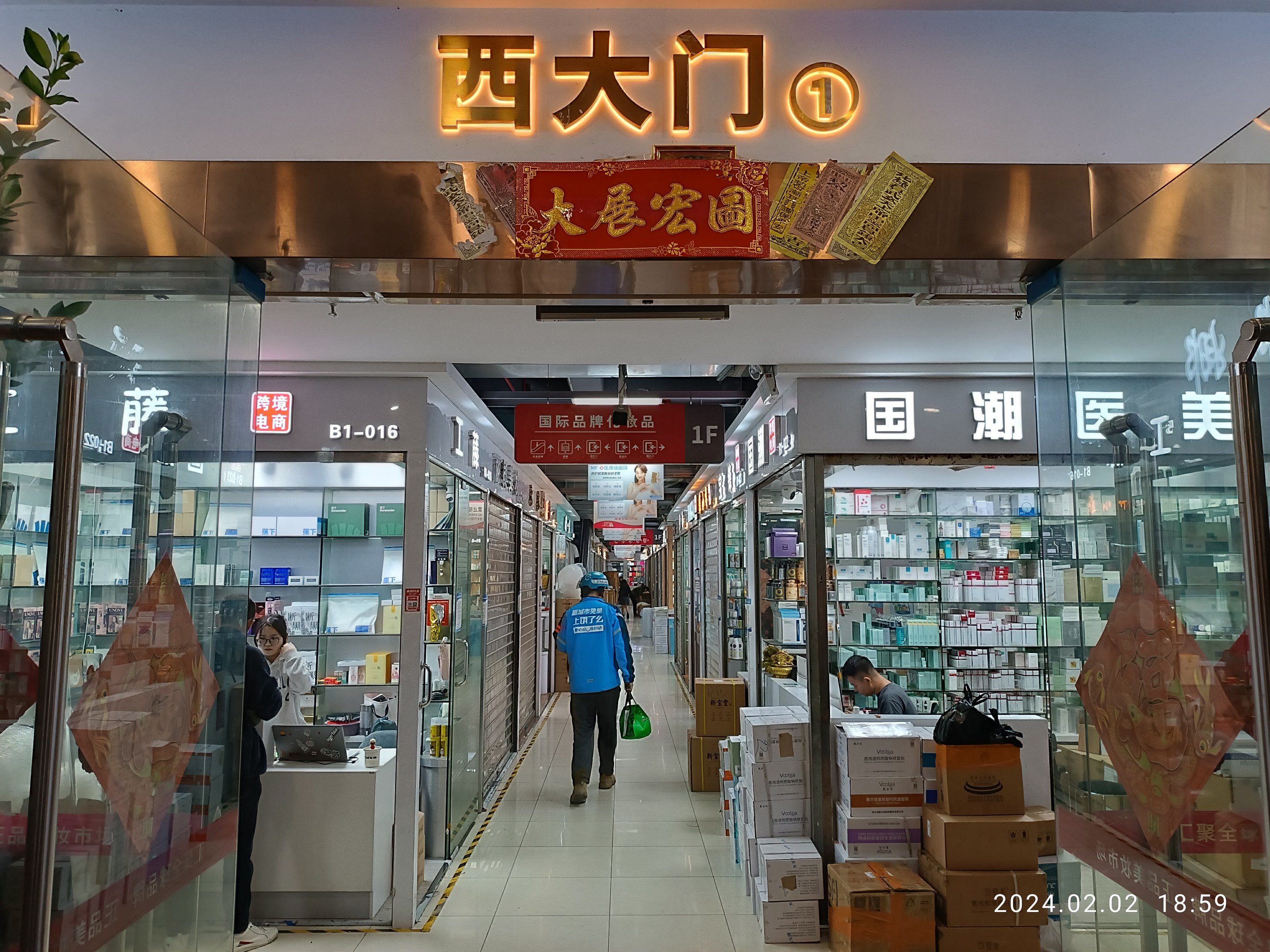 Innenansicht einer chinesischen Apotheke mit Glaswänden, Regalen voller Artikel, verstreuten Kartons, einer Pflanze auf der linken Seite und einem Namensschild oben, das auf eine chinesische Drogerie hinweist.
