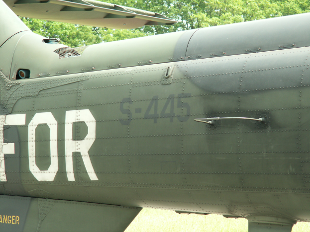 Ein Nahaufnahme eines Militärhubschraubers Mit Dem Wort "FOR" Darauf, Umgeben Von Bäumen Im Hintergrund.