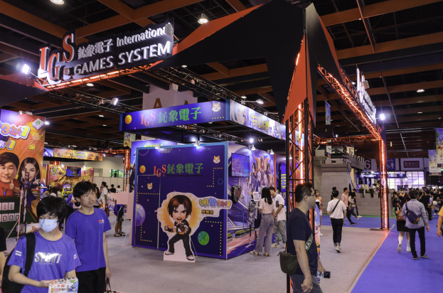 Eine Gruppe von Menschen durchquert einen Ausstellungssaal auf einer Gaming-Messe in China, einige tragen Taschen und halten Gegenstände, mit Displaytafeln, Deckenbeleuchtung und Teppichboden.