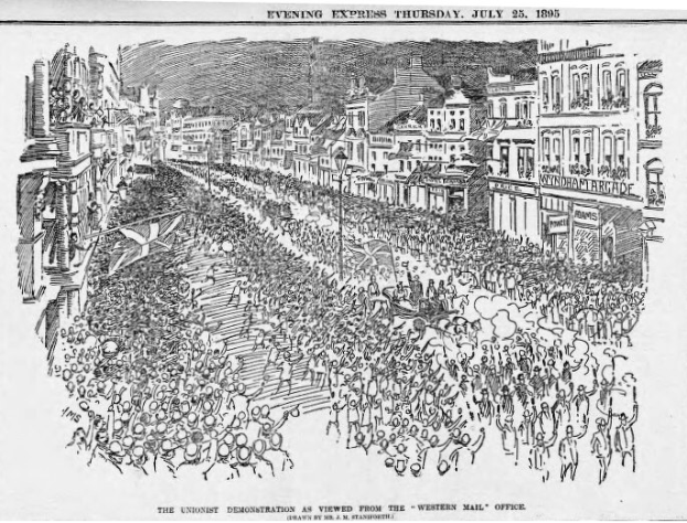 Schwarze und weiße Zeichnung einer Menge, die eine von Gebäuden gesäumte Straße entlanggeht, mit Text oben und unten: "Die Unionisten-Demonstration von der Western Mail Office aus betrachtet."