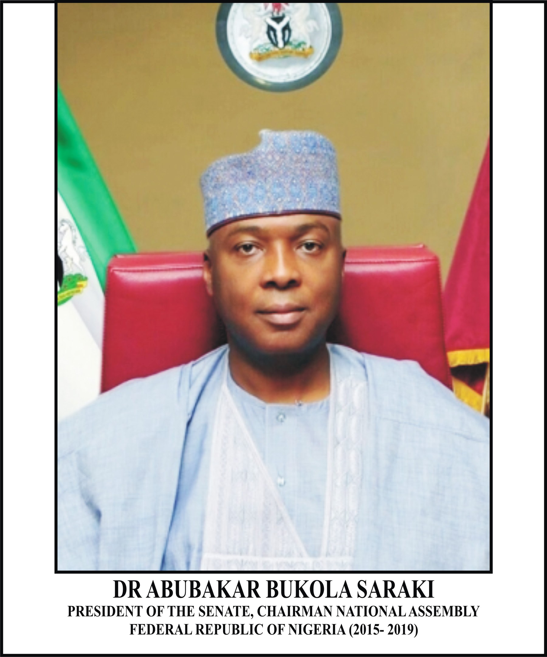 Dr. Abubakar Bukola Saraki, Präsident des Senats, sitzt in einem blauen Gewand und Hut mit zwei Flaggen und einem Logo dahinter und einem Rahmen mit Namen unten.