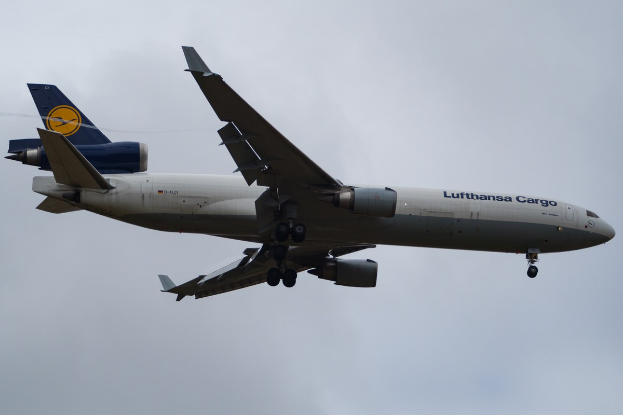 Lufthansa Cargo Boeing 777-300ER Flugzeug im Flug mit sichtbarem Text auf dem Rumpf und weißen Wolken im Hintergrund.