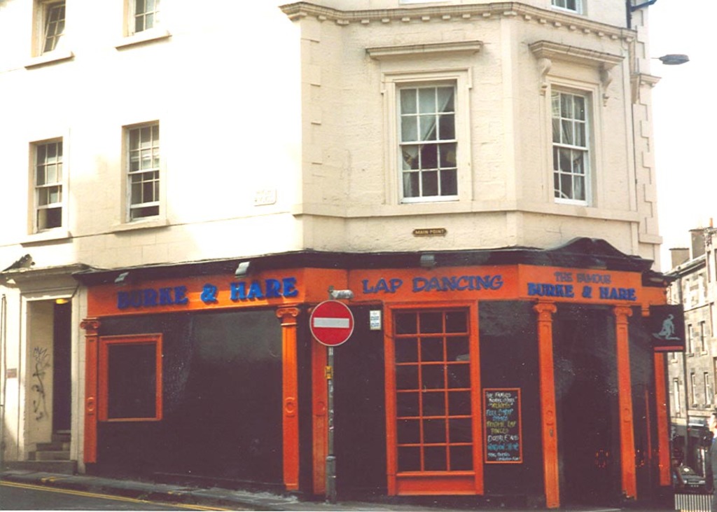 Ein Gebäude mit Fenstern, Türen und Text auf der Fassade.