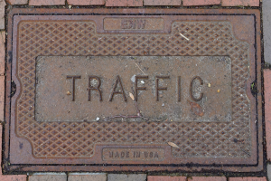 Ziegelweg mit einem Metall-Schachdeckel beschriftet mit "Verkehr."