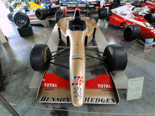 Rennwagen im Motorsportmuseum, getrennt von Besuchern und Infotafeln durch einen Metallzaun.