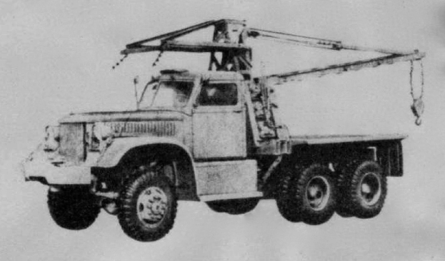 Ein Schwarz-Weiß-Foto eines großen, vierrädrigen Trucks mit einem Kran auf der Rückseite und einem Anhänger.