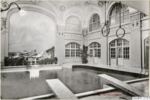 Altes Schwarz-Weiß-Foto eines großen Hallenbads in Rensburg, Deutschland, mit Glasfenstern, Pflanzen und einer Hängelampe.
