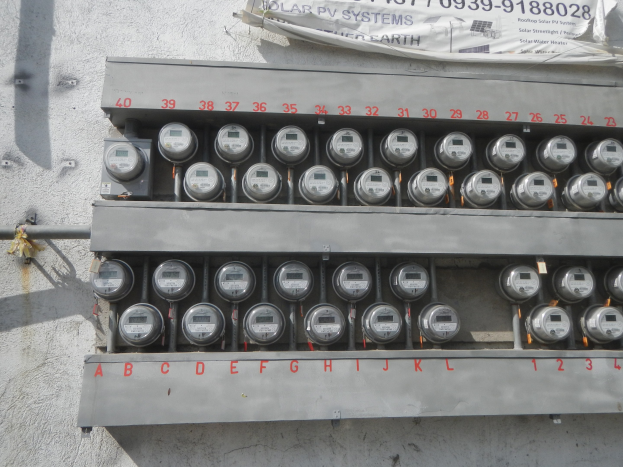 Nahaufnahme eines Stromzählers an der Seite eines Gebäudes mit einem Banner darüber, auf dem Text steht.