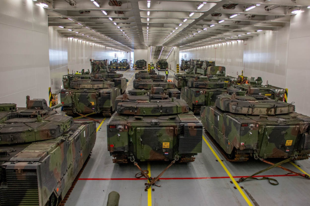 Eine gro├če Militargelandehalle mit Reihen von Militartanks, Wanden auf beiden Seiten und Deckenleuchten.