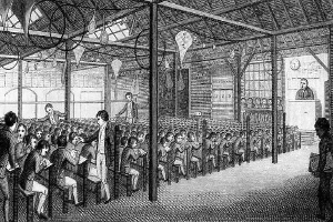 Schwarzes und weißes Zeichnung eines Klassenzimmers mit sitzenden und stehenden Menschen, mit Stangen, Lampen, einer Wanduhr und anderen Hintergrunddetails, mit Text unten lesend "The School of Economics, London, England."